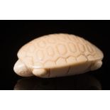 A Japanese carved ivory netsuke: Meiji period (1864-1912), in the form of a stylised turtle, signed,