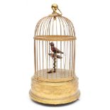 A French clockwork automaton singing bird in cage: the clockwork operated feathered bird on a