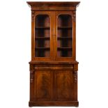 A Victorian mahogany bookcase:, the upper part with an overhanging ledge and ogee moulded cornice,