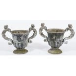 A pair of lead garden urns: of neoclassical form with half reeded decoration,