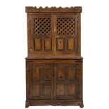 An early 18th Century Continental oak food cupboard:, the upper part with a castellated pediment,