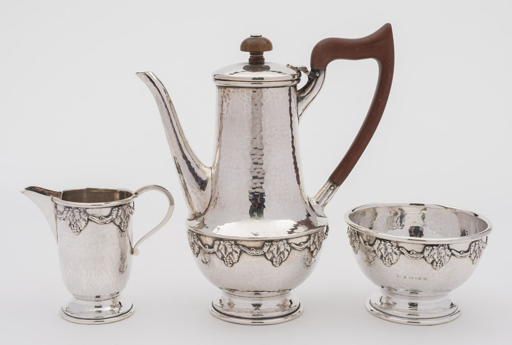 A George V hammered silver three-piece bachelor's coffee service, maker Albert Edward Jones,