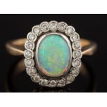 A 9ct gold, opal and diamond oval cluster ring: the oval opal approximately 9mm long x 7mm wide,