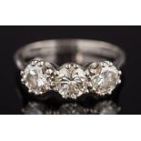 An 18ct white gold and diamond three stone ring: with circular,