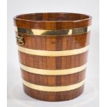 A 19th Century teak and brass bound peat barrel:, with brass carrying handles to the sides,