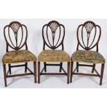 A set of six George III mahogany dining chairs in the Hepplewhite taste:,