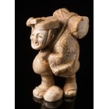 A Japanese carved ivory okimono: Meiji period (1864-1912) of a travelling musician with a drum on