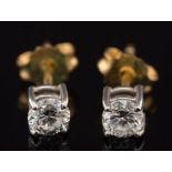 A pair of diamond single stone ear studs: each with a circular brilliant-cut stone approximately 0.