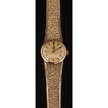 A lady's 9ct gold Omega wristwatch: the circular gold colour dial with baton markers in a 9ct gold