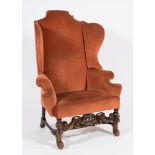 A 17th Century and later carved walnut wing back armchair:,