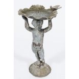 A lead bird bath: in the form of a putto supporting a clam shell above his head,