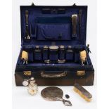 A George V period blue leather vanity case containing silver topped bottles, maker Finnigans Ltd,