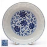 A Chinese blue and white peony saucer dish: painted with a medallion of scrolling peony flowers and