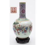 A Chinese porcelain bottle vase: enamelled in the famille rose palette with a procession of