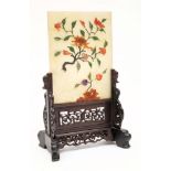 A Chinese hardstone table screen and wood stand: the rectangular panel applied with a knarled peony