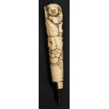 A Japanese carved ivory parasol handle: the handle depicting Daikoku,