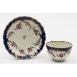 A Worcester fluted tea bowl and saucer: painted with floral swags below a royal blue border,