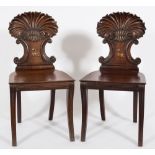 A pair of Regency carved mahogany hall chairs:,