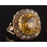 A yellow sapphire and seed-pearl cushion-shaped cluster ring: with central cushion-shaped sapphire