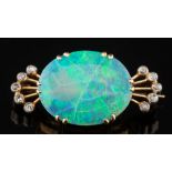 An opal and diamond brooch: with central oval opal 19mm long x 15mm wide claw-set between