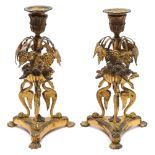 A pair of 19th century French ormolu candlesticks: with foliate decorated urn nozzles,