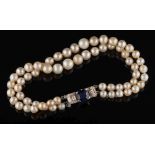 A graduated pearl/cultured pearl two-string bracelet: with sapphire and diamond mounted clasp:,