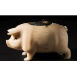 An early 20th century carved ivory pin cushion in the form of a pig: with inset glass eyes and