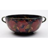 A Moorcroft pottery two handled bowl: of circular form tube lined in the Pomegranate pattern in red,