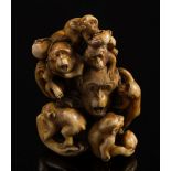 A Japanese carved ivory okimono of a group of monkeys: some holding nuts and fruit, signed Masatami,