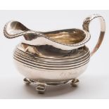 A George IV silver cream jug, maker's mark worn, London, 1825: inscribed, of barge-shaped outline,