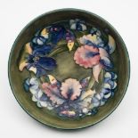 A Moorcroft pottery bowl: of circular form tubelined in the Orchid pattern in blue, red,