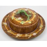 A George Jones majolica butter dish and cover: of circular form with rustic handle,