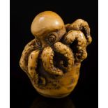 A Japanese carved ivory netsuke of an octopus emerging from a shell: signed Tomoyuki, Meiji period,