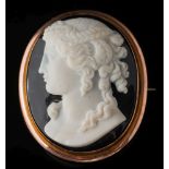 A layered agate cameo oval brooch: the black and white cameo depicting a young woman looking to