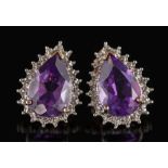 A pair of amethyst and diamond pear shaped ear studs: each with a central pear-shaped amethyst