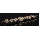 A rose diamond mounted bar brooch: with seven graduated stones in millegrain settings.