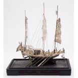 A Chinese white metal model of a three-masted war junk: fitted with cannon and oars, 24cm.