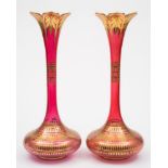 A pair of large Bohemian ruby stained and gilt vases: with slender necks and petal shaped rims,