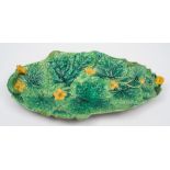 A George Jones majolica cucumber tray: of shaped oval form moulded with verdant leaves and yellow