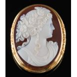 An oval hard-stone cameo portrait brooch: the oval cornelian and white agate layered cameo carved