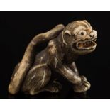 A Japanese carved ivory netsuke of a recumbent warthog: with inset eyes, signed, Meiji period, 4.