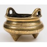 A Chinese polished bronze tripod censer: of squat circular form, with loop handles to the rim,