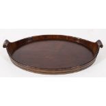 An 18th century mahogany and brass bound oval twin-handled tray:, having scroll handles,