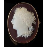 An agate oval cameo brooch: the cornelian and white cameo depicting a young woman looking to dexter,