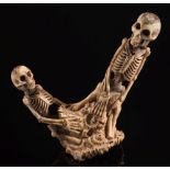 A Japanese carved antler okimono of two kneeling skeletons: unsigned, 10.5cm. high.