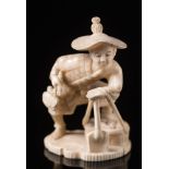 A Japanese carved ivory okimono: of a peasant wearing a straw hat, holding a basket and a spade,