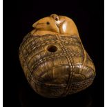 A Japanese carved ivory netsuke of a rat seated on a rope bound bale: with an articulated serpent's