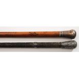 A 19th century Indian silver mounted carved ebony walking cane and one other white metal mounted