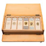 A pine slide case containing thirty five mineral specimens in six trays:, by Hensoldt and others.