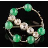 A jade and diamond circular brooch: set with a surround of jade beads each approximately 6mm